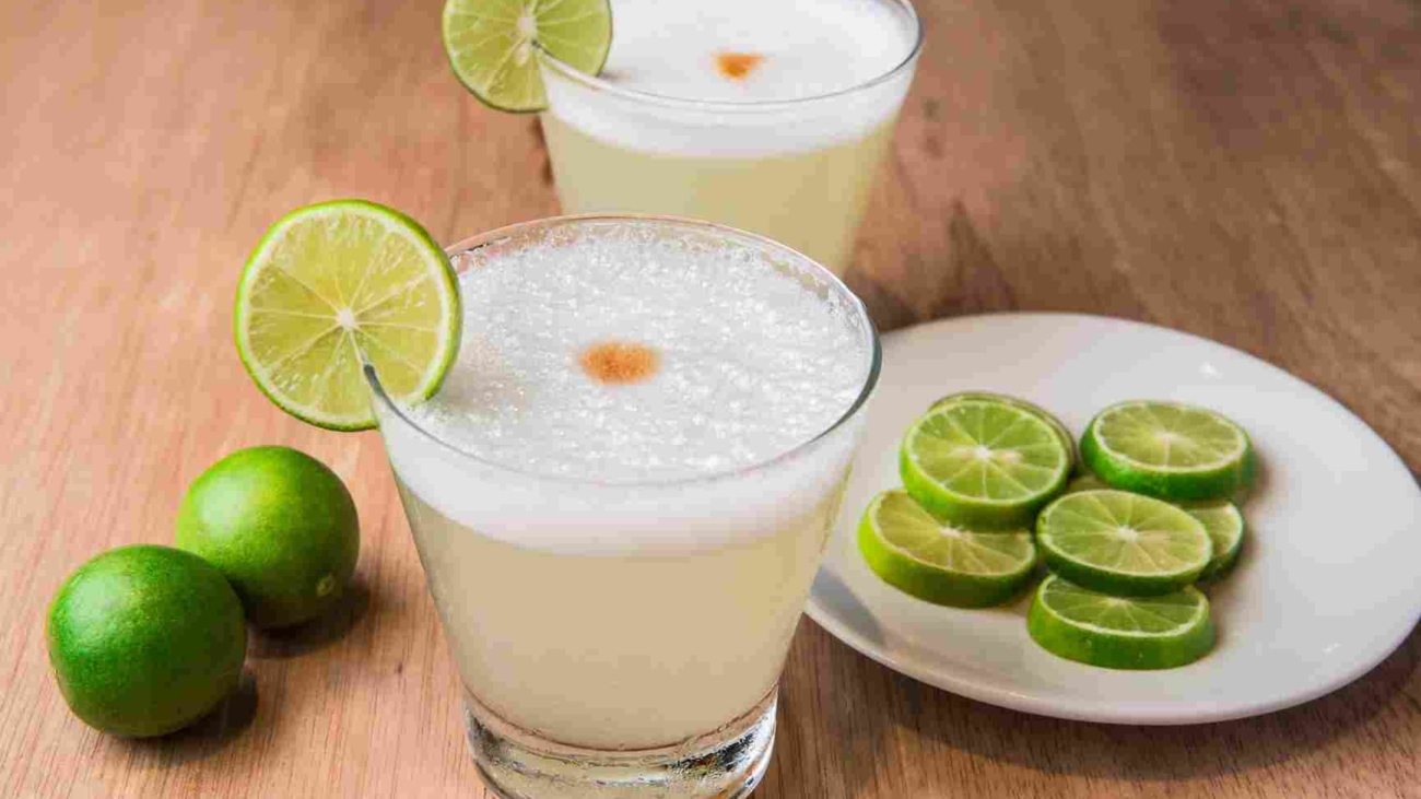 Peruvian,Drink:,"pisco,Sour",With,Lemon,On,Wooden,Background.
